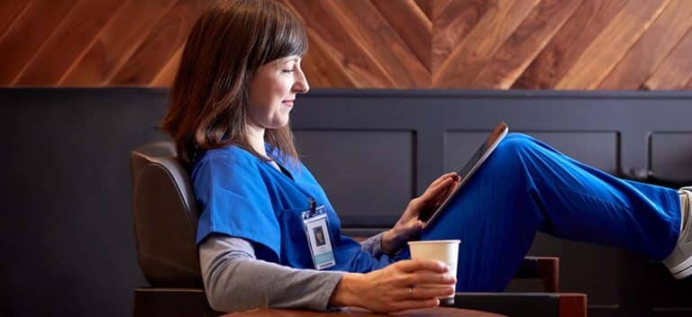 Nurse practitioner checking salary trends in her work break
