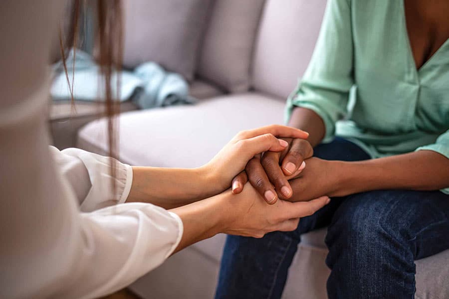 Social worker holding hands of a patient