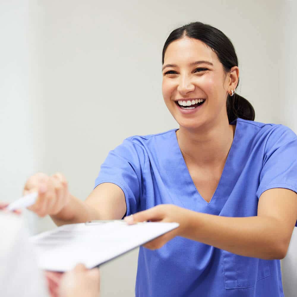 medical assistant giving sign up documents to patient